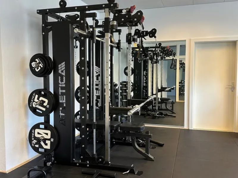 Trainingsraum der Praxis körperlich mit Rack, Kabelzug und Hantelscheiben