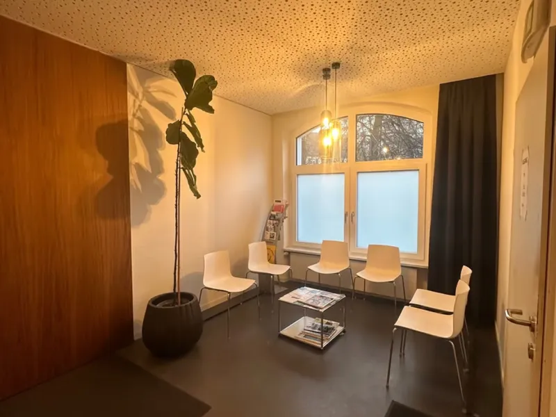 Wartezimmer der Praxis körperlich mit Stühlen und großer Pflanze